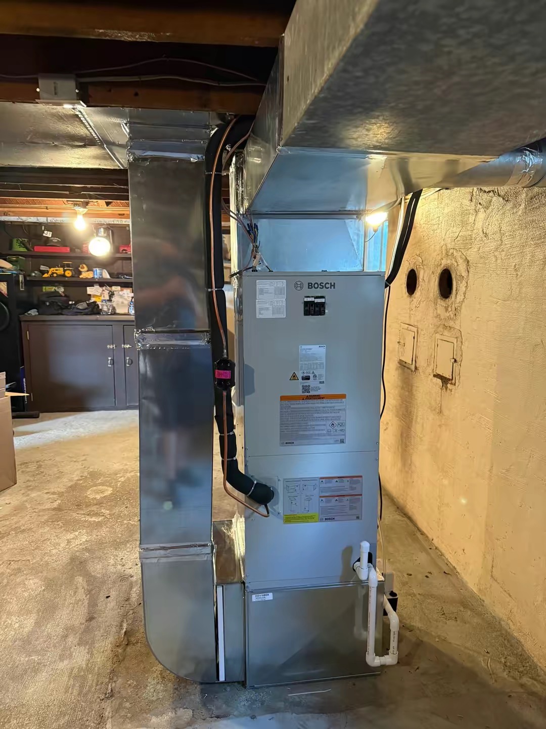 Bosch air handler connected to new sheet metal ductwork in a basement